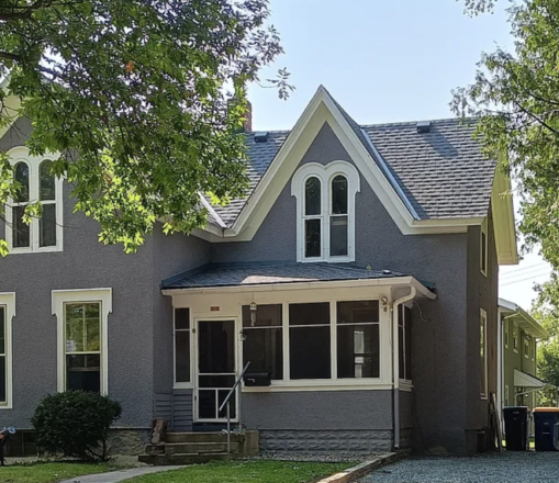 A blue-gray house with white trim.